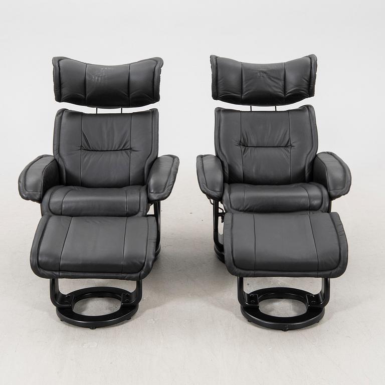 A pair of leather easy chairs and footstools from the 21st century.