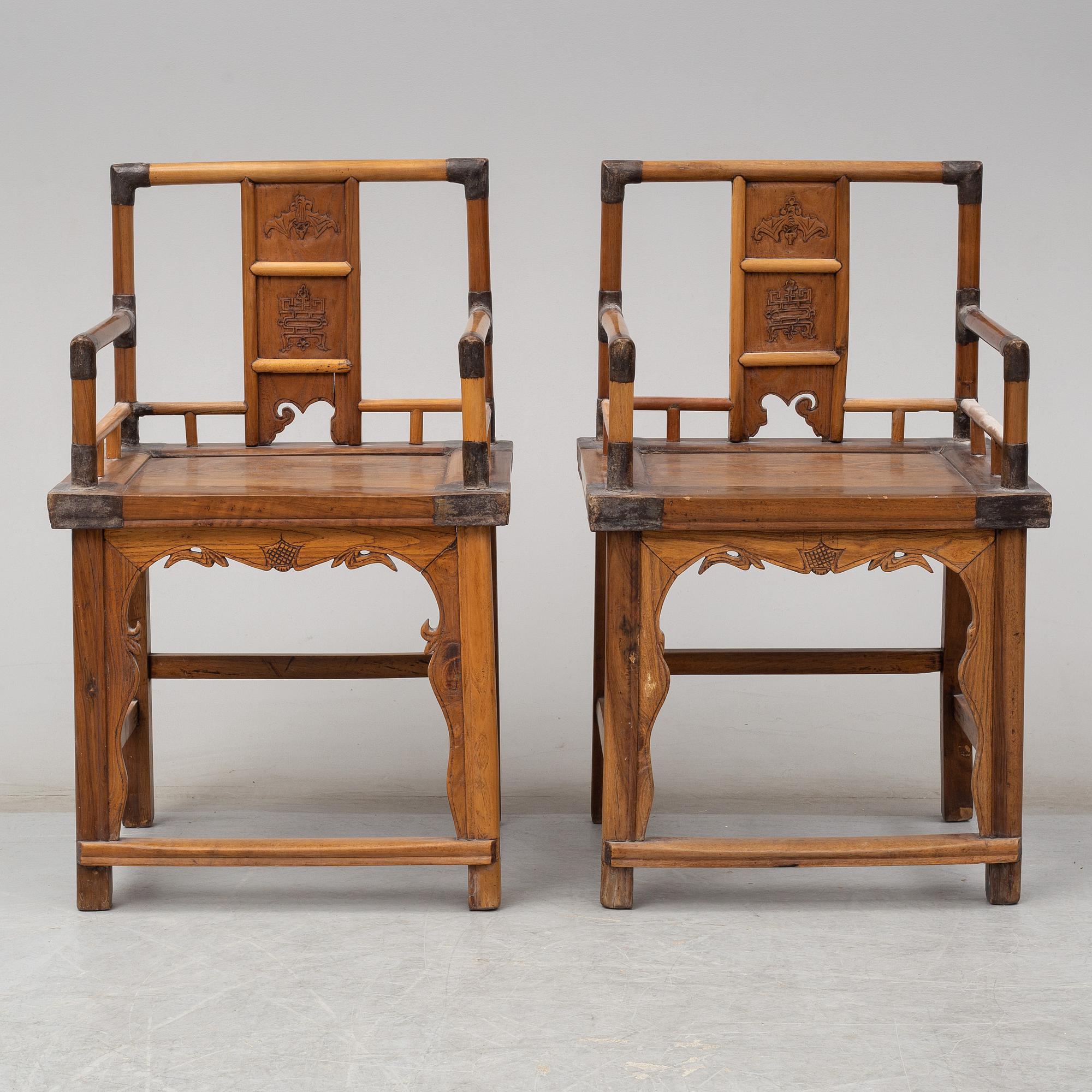 A pair of Chinese wooden armchairs, late 19th/early 20th century.