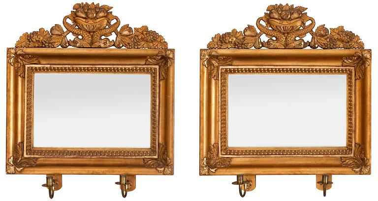 A pair of Swedish Empire first half 19th century two-light girandole mirrors.