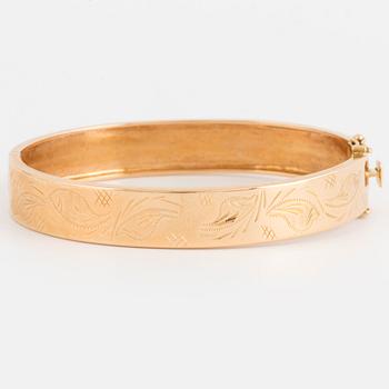 An 18K gold bangle.