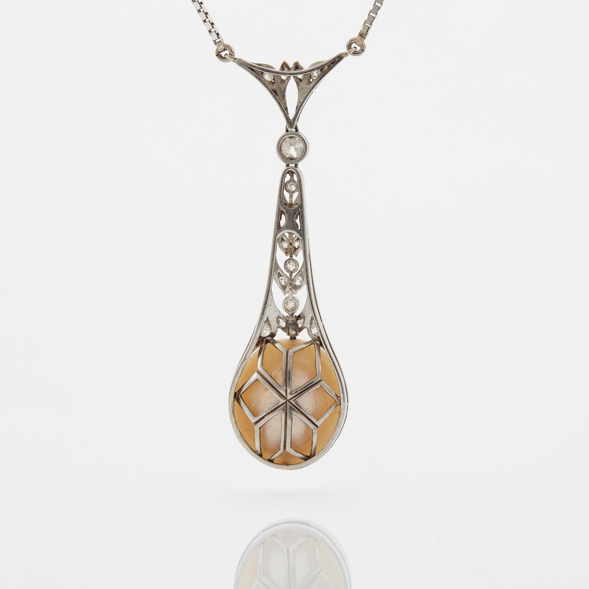 A platinum pendant set with a half pearl and old-cut diamonds.