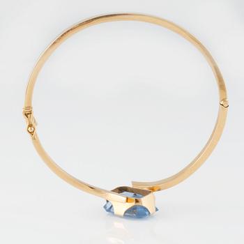 ARMRING, 18K guld med fasettslipad syntetisk blå spinell, Svenskt Guldsmide, Stockholm, 1956. Vikt 9,8 gram.