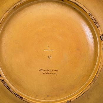 A wall plate by Adolf Neumann, Rörstrand, signed on verso 1884.