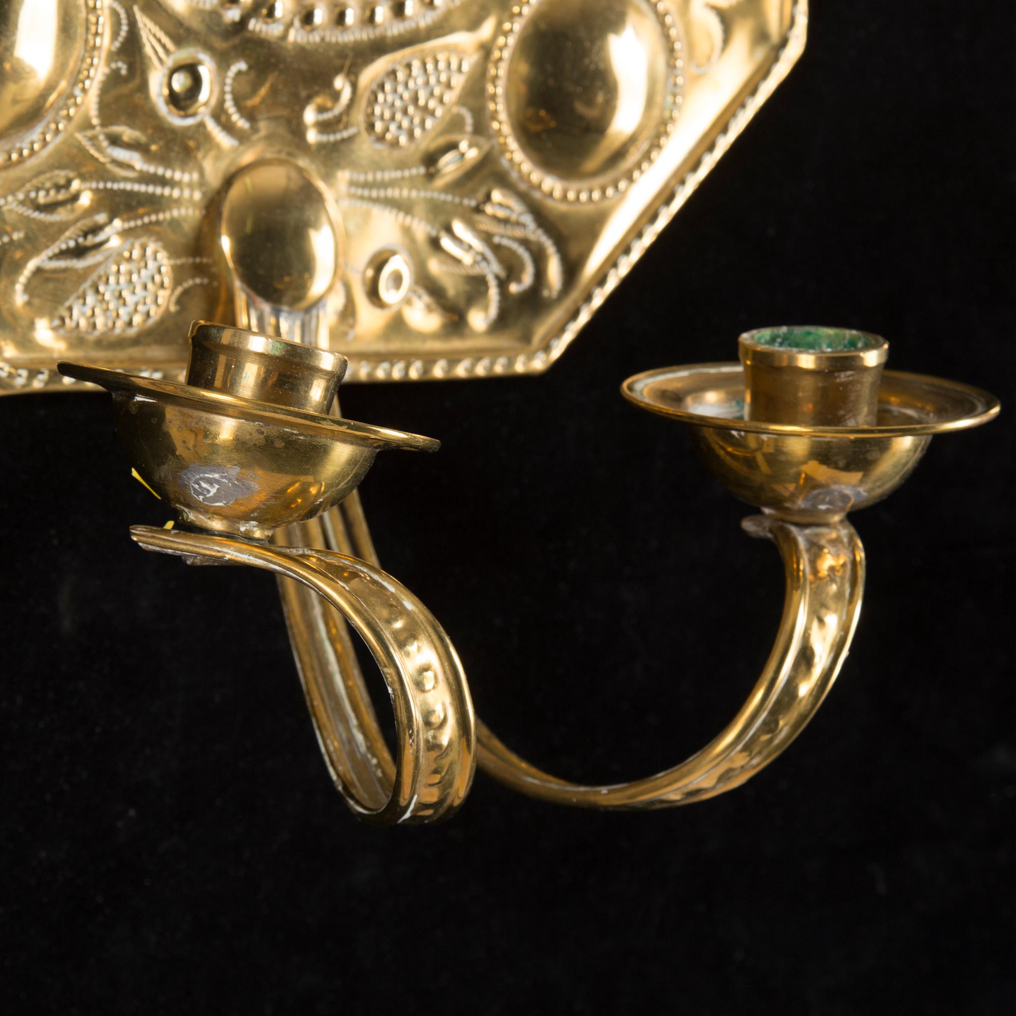 A pair of first half of the 20th century brass two-light wall sconces.