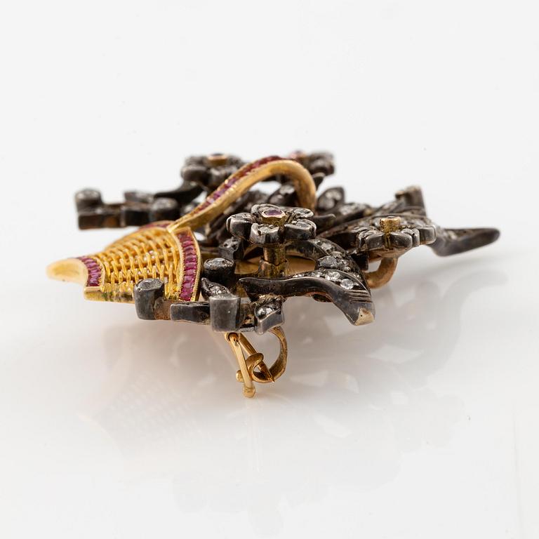 A brooch in 18K gold with diamonds and rubies in the form of a flower basket.