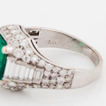 A Bulgari "Trombino" ring in platinum set with a step-cut emerald and round brilliant- and baguette-cut diamonds.