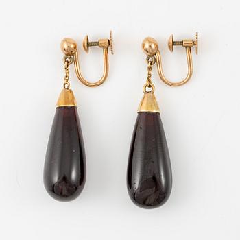 A pair of 14K gold earrings with garnet drops.