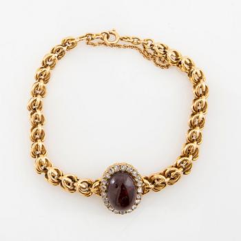 Armband 18K guld med rosenslipade diamanter och en ovalt cabochonslipad granat.