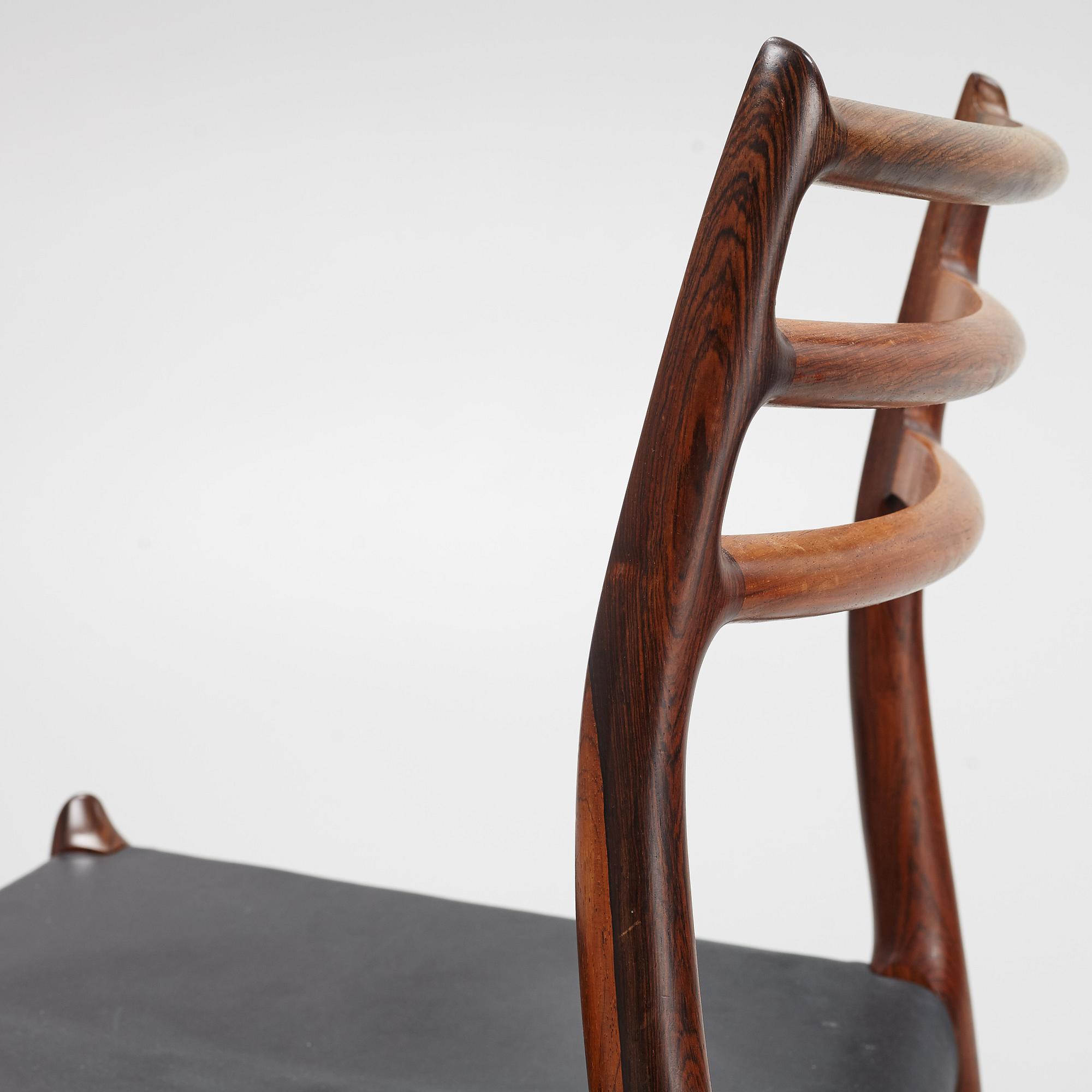 Niles Otto Møller, a rosewood veneered table with four chairs, JL Møller, Denmark, 1950's/60's.