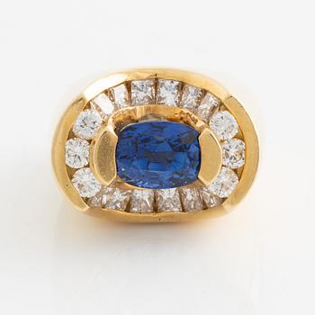 582. An 18K gold ring set with a faceted sapphire.