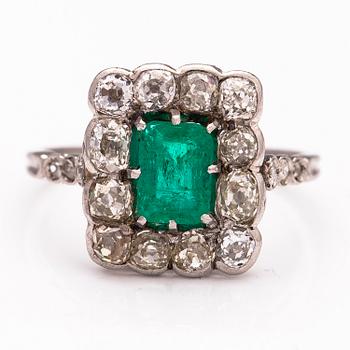 A platinum ring with an emerald ca 0.71 ct and old cut diamonds ca 1.66 ct in total.
