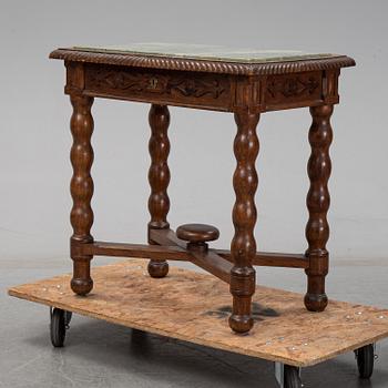 An early 20th Century oak side table with a stone top.