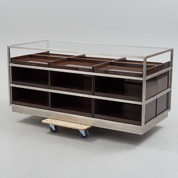 A modern glass and metal cabinet for shop use.