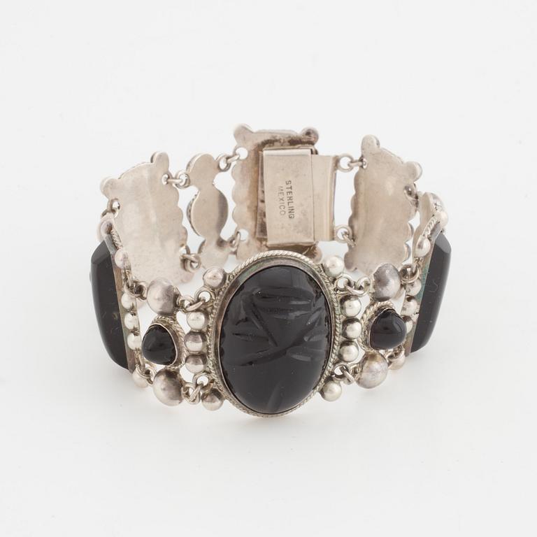 A silver belt buckle, three bracelets, two pairs of earrings, a pair of cuff-links and a brooch.