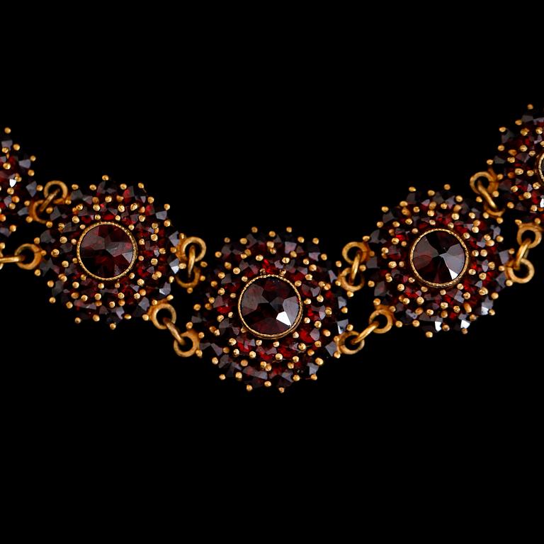 COLLIER OCH ARMBAND, förgylld metall och granater, 1900-talets andra hälft.