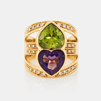 1032. An 18K gold ring set with facted amethyst and peridot in the form of two hearts.