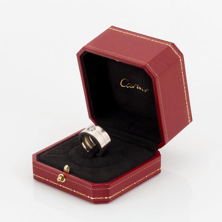 A Cartier 18K white gold ring set with a round brilliant-cut diamond.