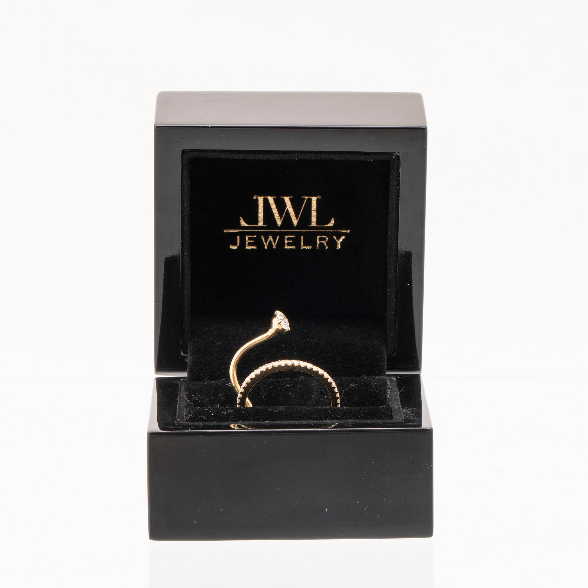 An 18K gold ring set with an oval cut and round brilliant cut diamonds by LWL Jewelry.
