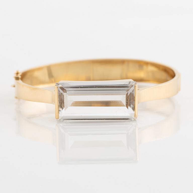 An 18K gold bangle set with synthetic spinel.