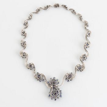 An 18K white gold necklace set with round brilliant-cut diamonds and sapphires.