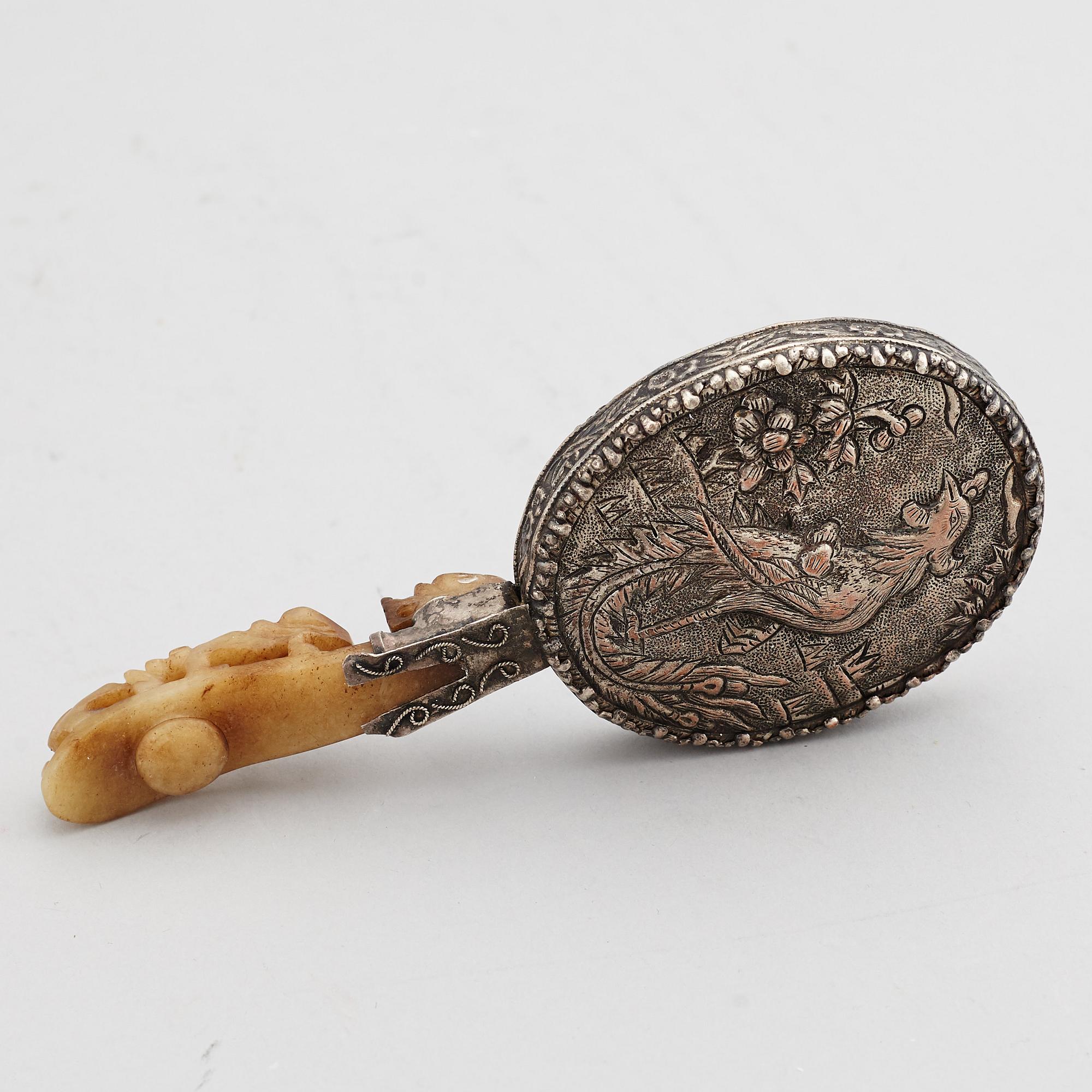 A silver gilt copper mirror with nefrite handle in the shape of a belt hook.