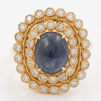 Ring in 18K gold set with a cabochon-cut sapphire and brilliant-cut diamonds.