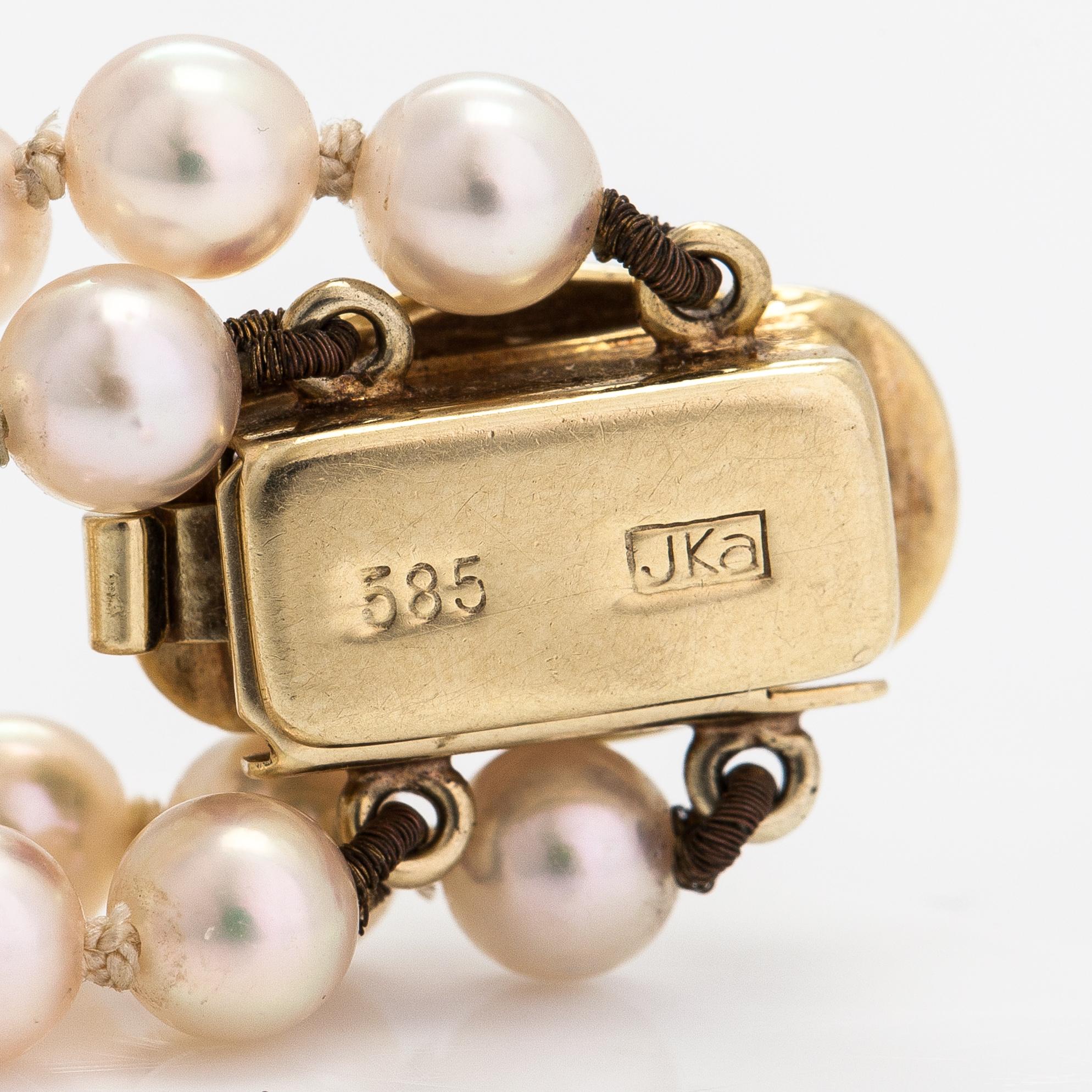 A 2-strand pearl bracelet with cultured pearls, lock 14K gold and diamonds, ca 0.13 ct in total.