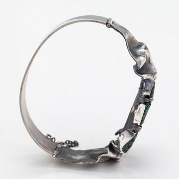 Reino Saastamoinen, Armband "Maahiset", siver och zoisit med rubinkristaller. Helsingfors 1968.