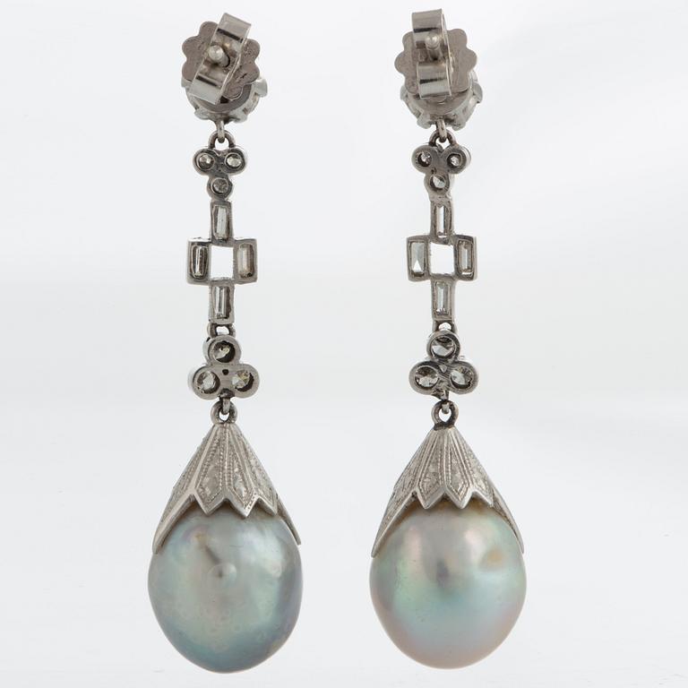 A pair of drop-formed pearl earrings in a box from Cartier.