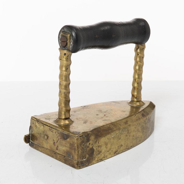 A brass clothes' iron, dated 1773.