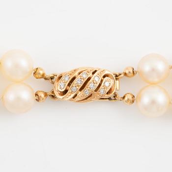 Necklace of two strands of cultured pearls, clasp with 18K gold lock set with eight-cut diamonds.