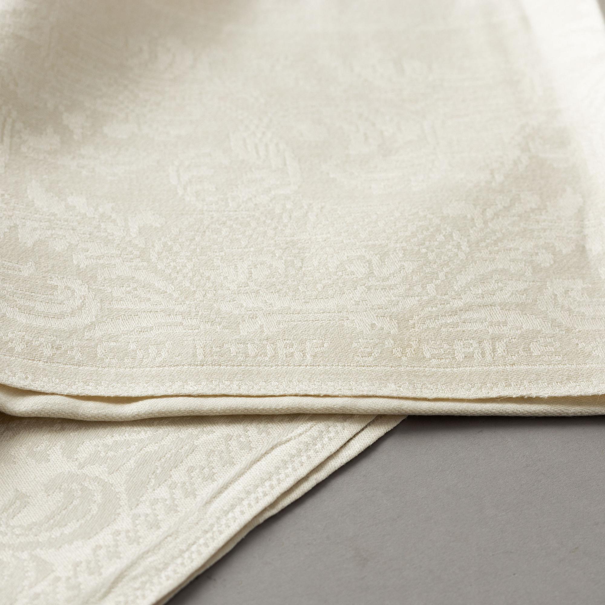 A tablecloth and napkins, 8 pcs., linen damask, "Strödda blommor", signed C.W. T:tORP, SVERIGE.