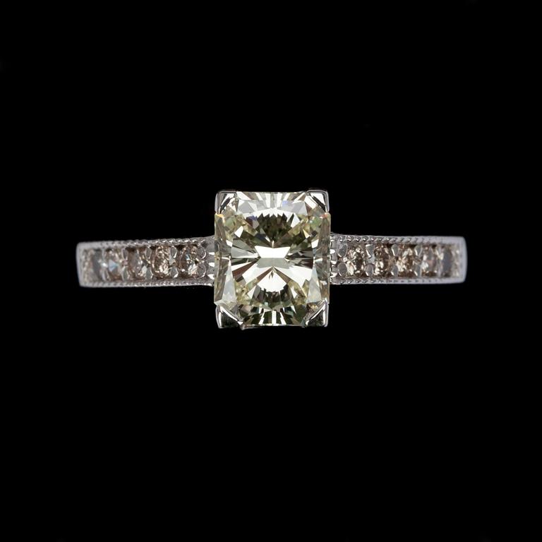 RING, vitguld 14K, mittsten 1,25 ct, sidostenar 10 st. tot. 0,15 ct. Vikt 2,9 g. Intyg.