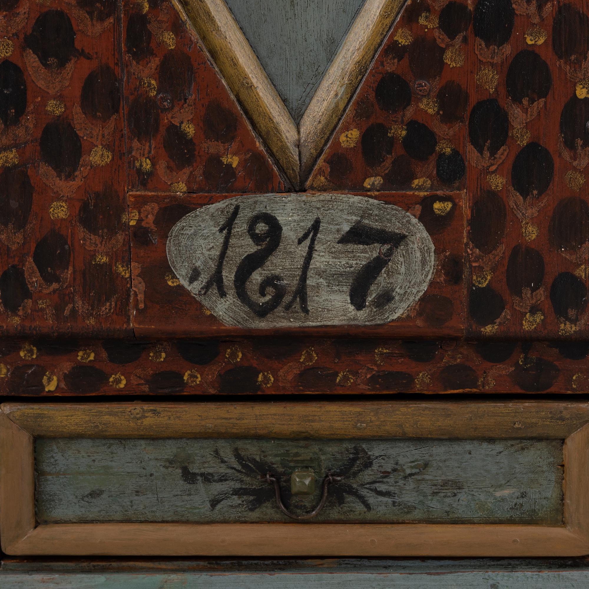 A painted wall cabinet, dated 1817.