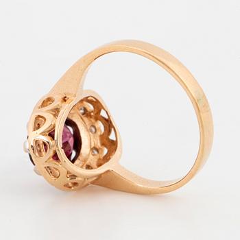 A 14K gold ring set with a garnet and eight-cut diamonds.