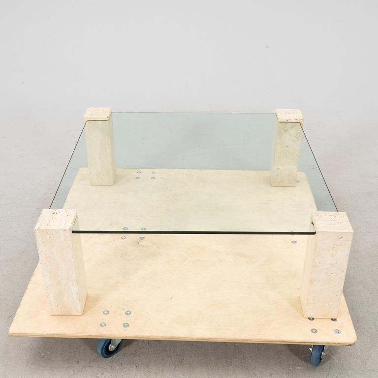 A late 20th century glass and travertin coffee table.