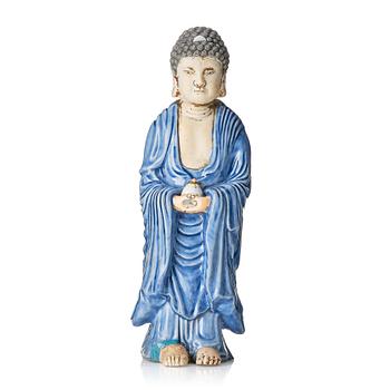 1093. A porcelain figure of a standing Buddha, Qing dynasty, 18th Century.