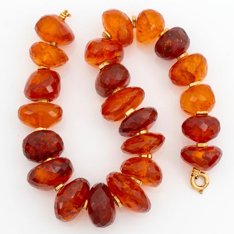 An amber necklace comprising graduated faceted amber beads ca 40 - 50 mm.