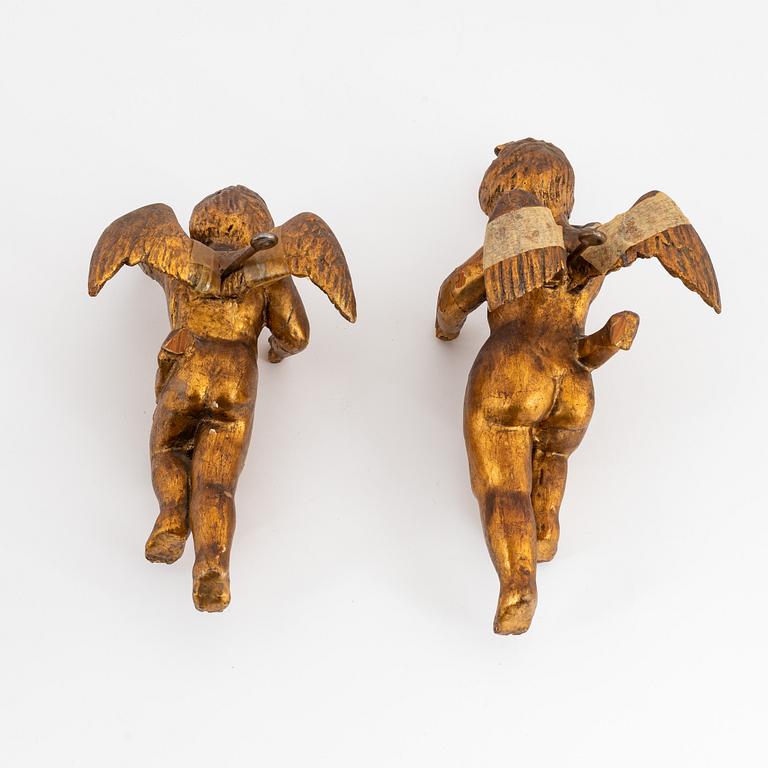 A pair of baroque wooden cupid sculptures, 18th century.