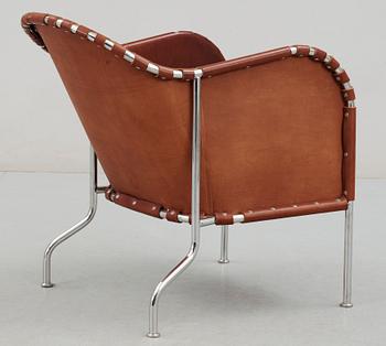 A Mats Theselius steel and brown leather easy chair.