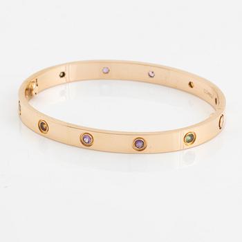 A Cartier "Love" bracelet in 18K rose gold set with colored stones.