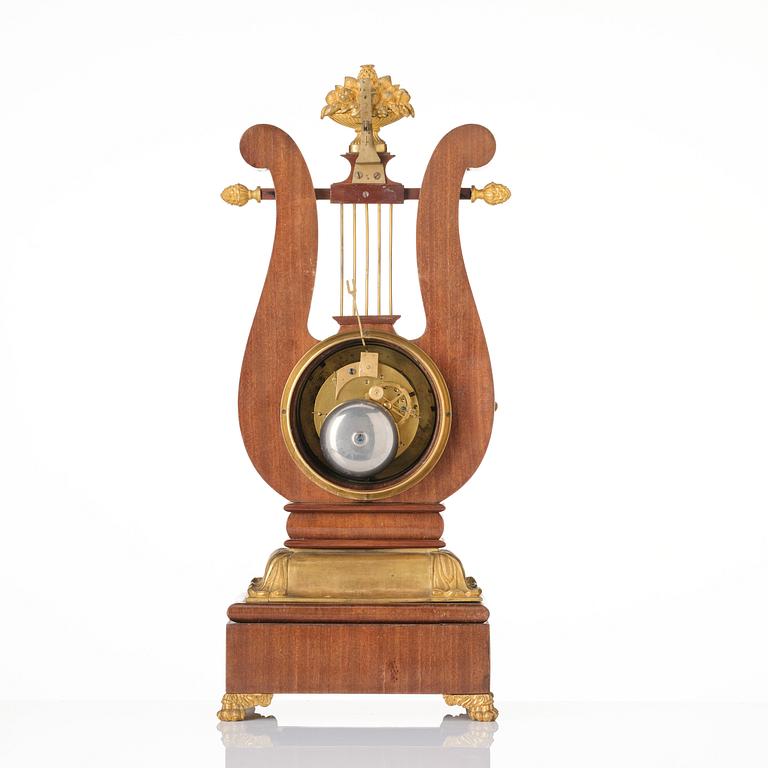 A French Empire mahogany, ormolu and gilt metal lyre-shaped mantel clock, early 19th century.