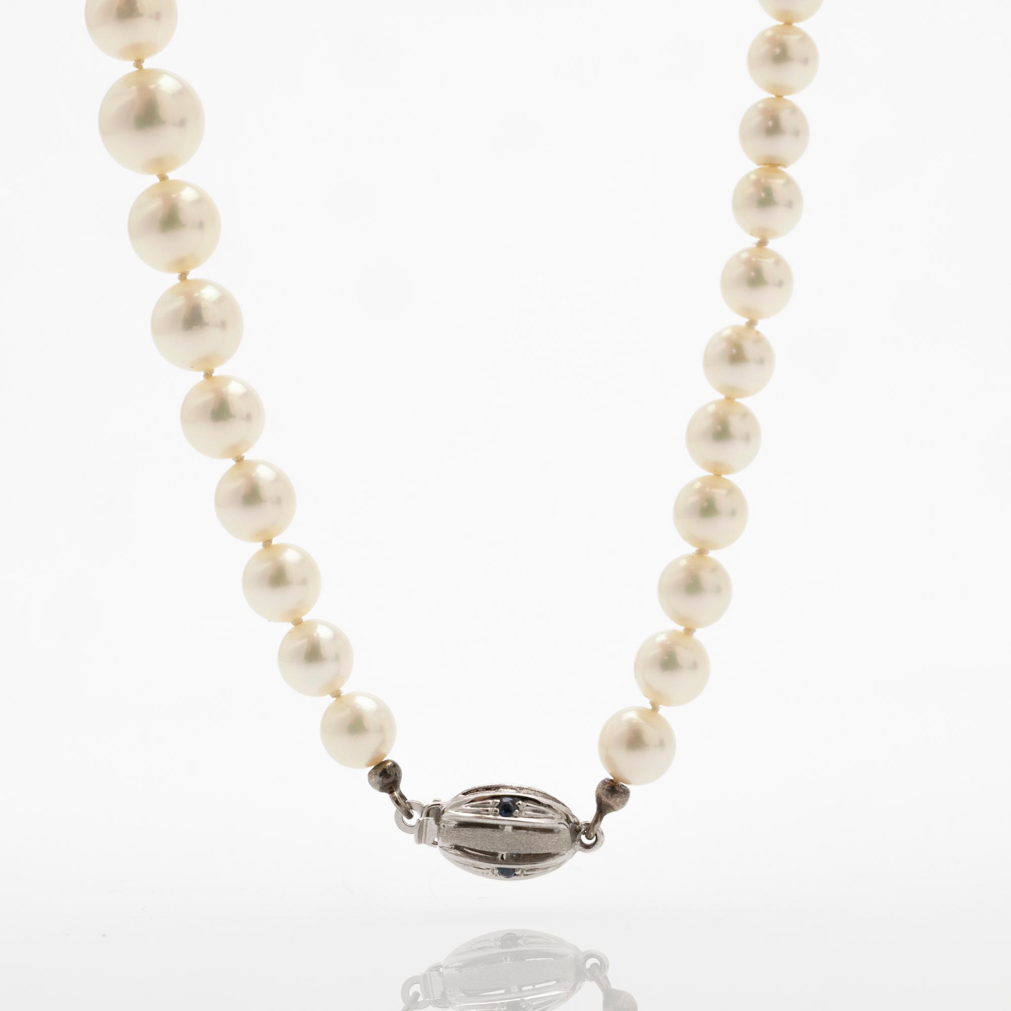 Necklace of cultured graduated pearls with an 18K white gold and sapphire clasp.