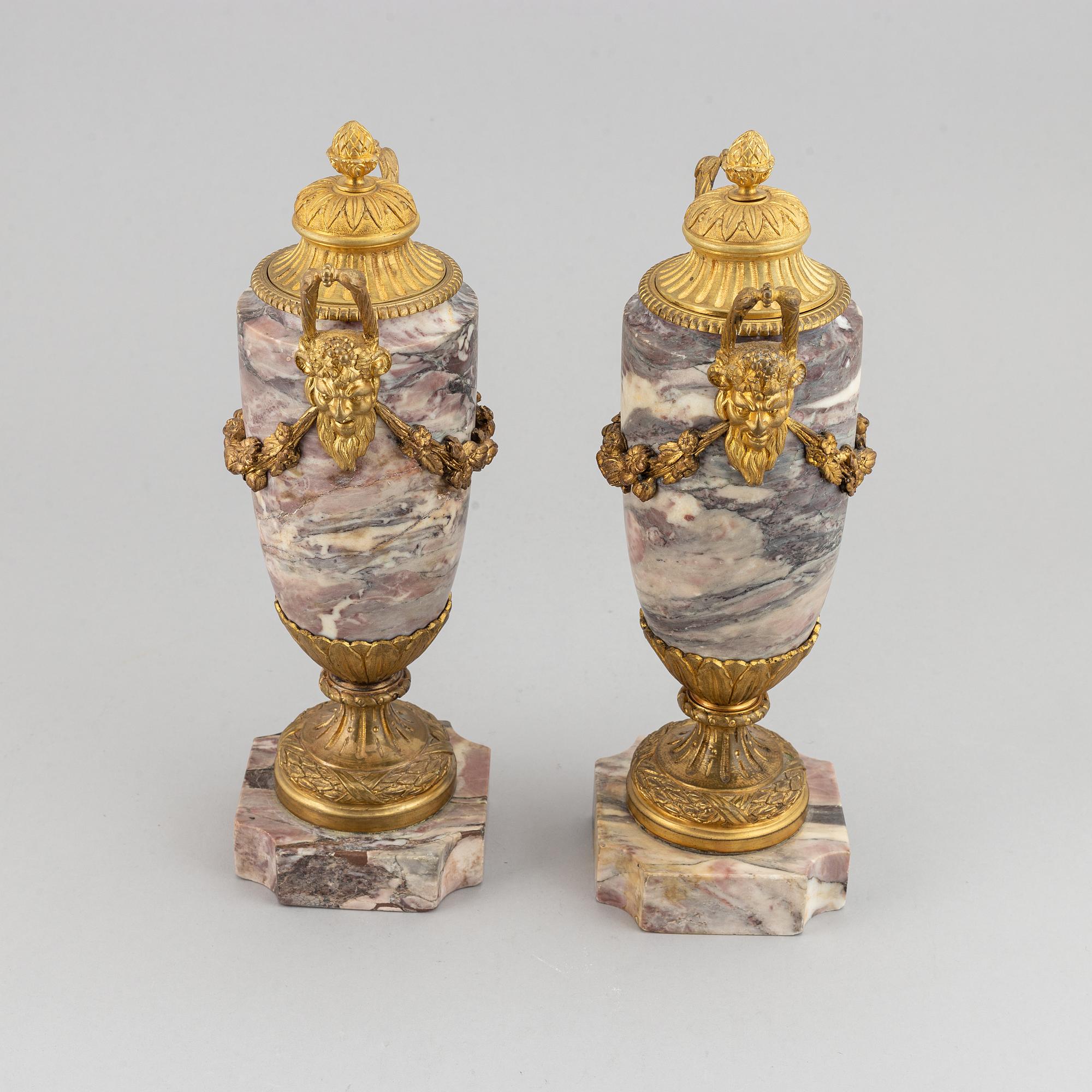 A pair of marble urns with bronze mountings from around year 1900.