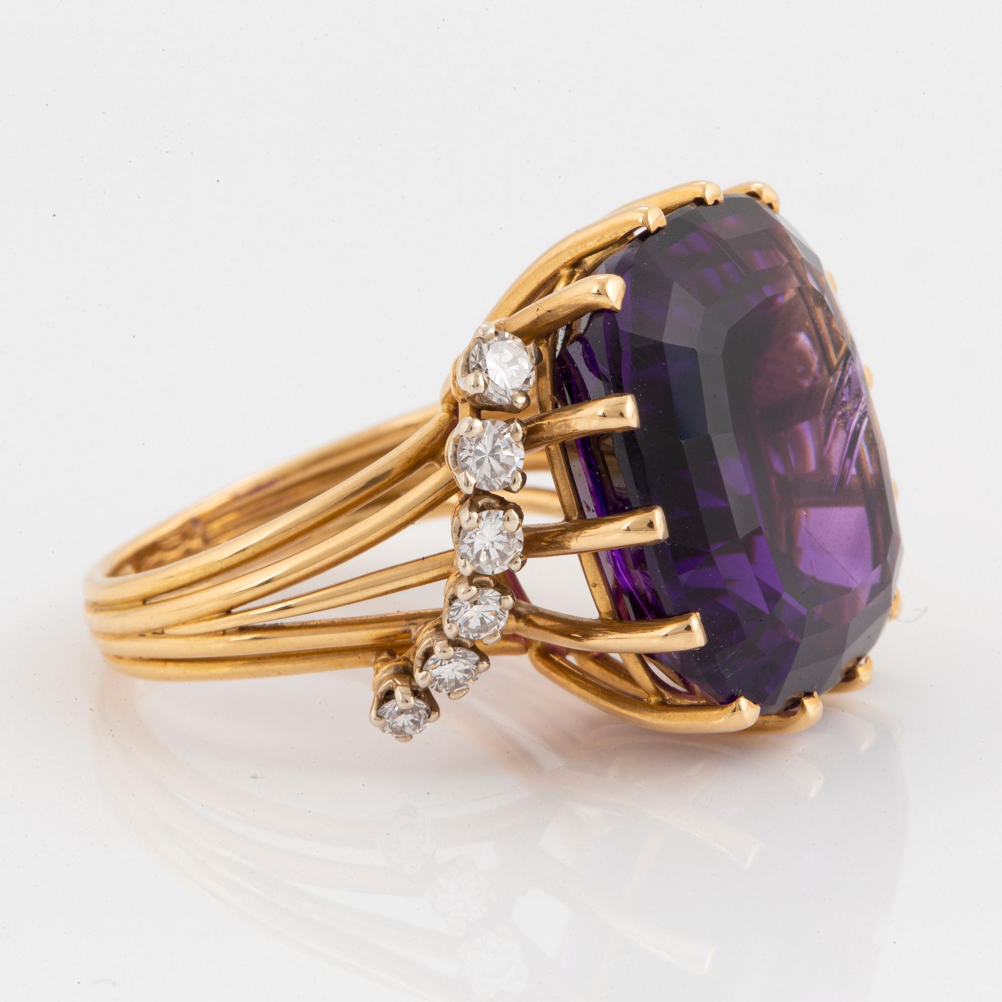 Ring 18K guld med en fasettslipad ametist och runda briljantslipade diamanter.