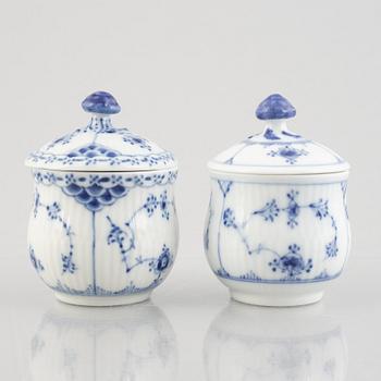 Two 'Blue Fluted' / 'Musselmalet rifflet' porcelain cream cups with covers, Royal Copenhagen, 19th century and 1964.