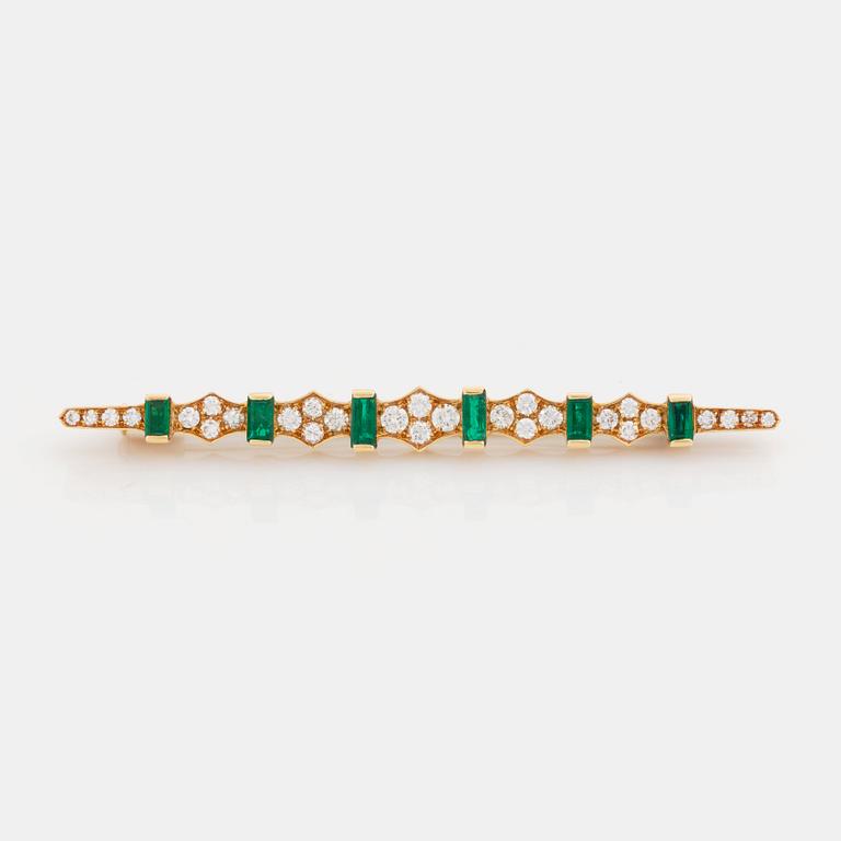 An 18K gold brooch set with step-cut emeralds and round brilliant-cut diamonds.