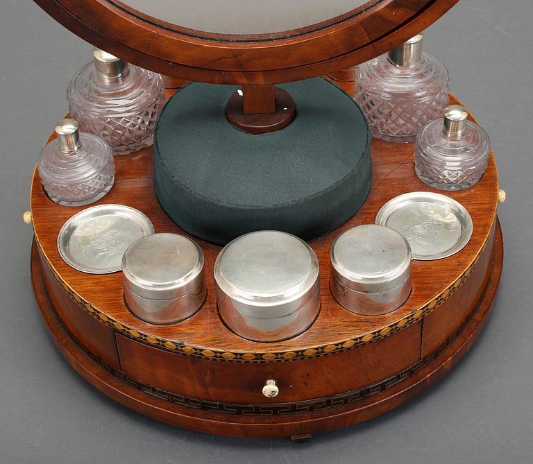 A Swedish Empire circa 1820 mirror on a stand for silver and glass toiletries.