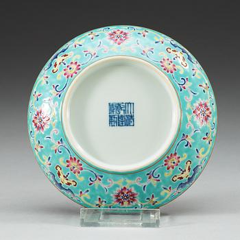 A turkoise ground famille rose dish, Qing dynasty, with Qianlongs seal mark.