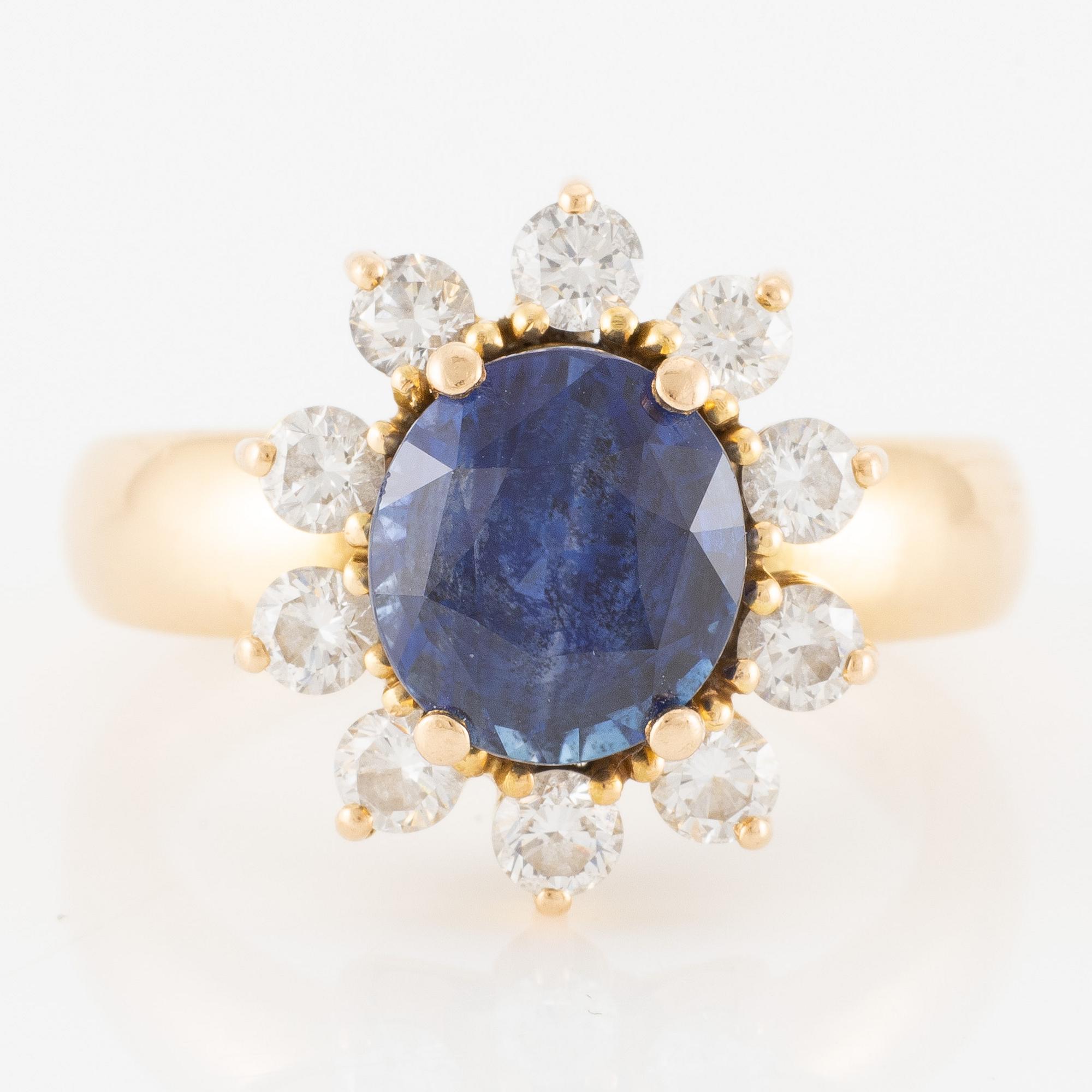 Ring 18K guld med en fasettslipad safir och runda briljantslipade diamanter.